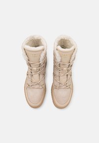 Lys beige vinterstøvler med kunstpelsfor, glat og struktureret læder, polstret krave og metaløjer til snørebånd.