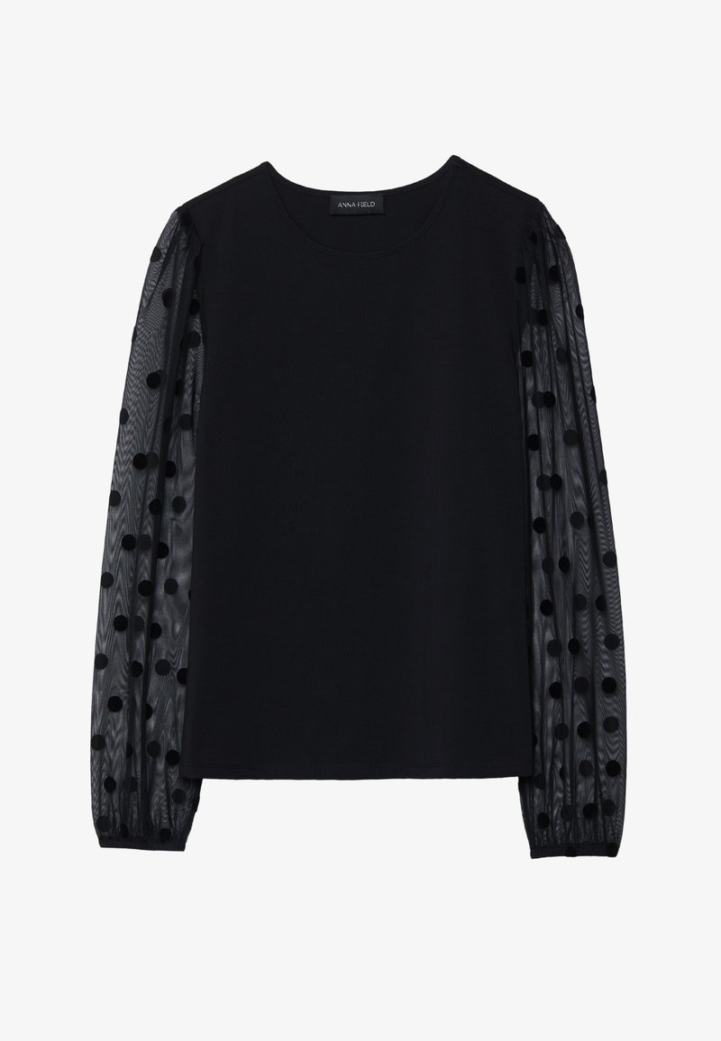 Schwarzes Top mit solidem Oberteil und transparenten, gepunkteten Ärmeln. Verfügt über einen runden Ausschnitt und Raffung an den Ärmeln.