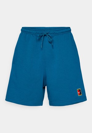 Blaue Baumwollshorts mit elastischem Bund und Kordelzug. Mit Seitentaschen und einem Logo-Patch in Rot, Gelb und Schwarz am Saum.