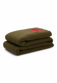 Coperta piegata di colore verde, realizzata in maglia con una finitura testurizzata, e dotata di un'etichetta rossa in un angolo. Misura circa 75 cm per 45 cm.