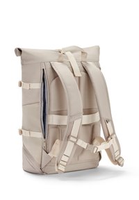 Beige színű, felhajtható hátizsák párnázott vállpánttal, cipzáras rekesszel és hálós részlettel a hátsó oldalán a szellőzés érdekében. Állítható oldalszíjak.