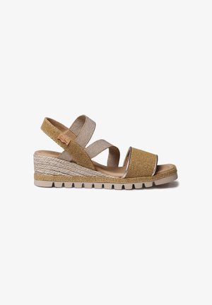 Sandale compensée beige avec brides croisées, texture tissée et détails en accent doré. Comprend une semelle intermédiaire de style jute tressée et une semelle extérieure en caoutchouc.