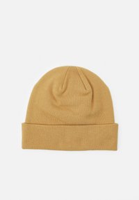 Berretto lavorato a maglia giallo senape con una texture morbida, dotato di risvolto e cima arrotondata. Design semplice, senza cuciture e senza decorazioni.