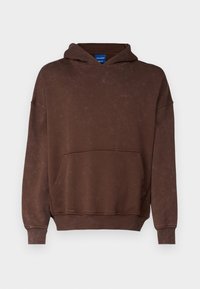 Sudadera marrón de tela suave, con bolsillo canguro, capucha con cordones y puños y dobladillo acanalados. Textura sutilmente descolorida en toda la prenda.