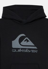 Črna kapuca s sprednjim žepom in kapuco na vezanje. Ima velik siv logotip Quiksilver z obliko vala in gore.