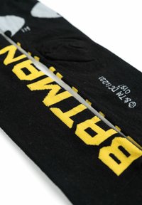 Calze nere con scritte gialle che recitano "SPITMAN" e dettagli grigi. Il materiale appare come un tessuto morbido con una finitura liscia.