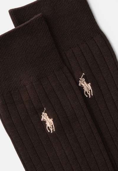 Brūnas ribotas zeķes ar mazām izšūtām zirglogo ārējā pusē gaišākā tonī. Tekstilmateriāls izskatās mīksts un elastīgs.