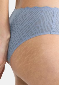 Világoskék csipkebetétű hipster alsó, fodros derékkal, geometrikus mintával és puha, texturált anyagból készült.