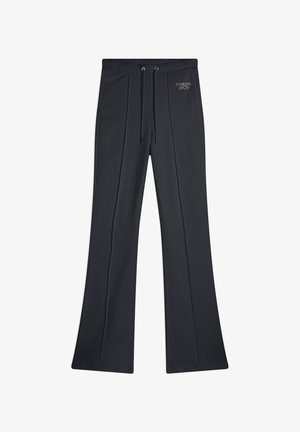 Pantalones de pierna ancha negros, fabricados en tejido suave, con cintura ajustable y pliegues frontales. Logo bordado en plata en la parte superior izquierda.