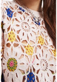 Pullover all'uncinetto rosa chiaro con motivi floreali in giallo, blu e verde, con una vestibilità ampia e un design a trama aperta. Collana in catena argentata inclusa.