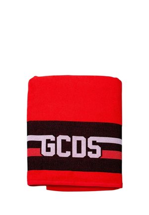 Rood gevouwen stof met zwarte en witte horizontale strepen en de witte letters "GCDS" gecentreerd op de zwarte streep.