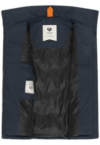 Giacca blu navy con un'etichetta arancione, interno realizzato in tessuto nero lucido con testo in rilievo ripetuto. L'etichetta include informazioni sulla taglia.