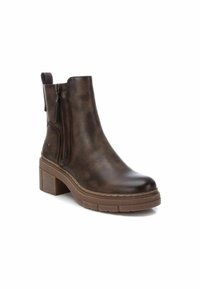 Botas de tobillo de cuero marrón con un tacón grueso, cremallera lateral y tirador. Textura suave con sutiles variaciones en el color y el acabado.