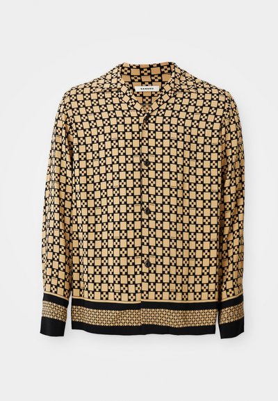 Langsleeve shirt met een geometrisch zwart en beige patroon, met een kraag en knoopsluiting. Aangekleed met zwarte manchetten en zoom.