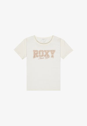 Krema spalvos marškinėliai su žodžiu "ROXY" drąsiu, stilizuotu šriftu, šalia "Nuo 1990" mažesniu kursyvu žemiau.