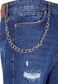 Jean en denim bleu avec une chaîne de poche avant fixée aux passants de ceinture et un détail déchiré effiloché sur la cuisse.