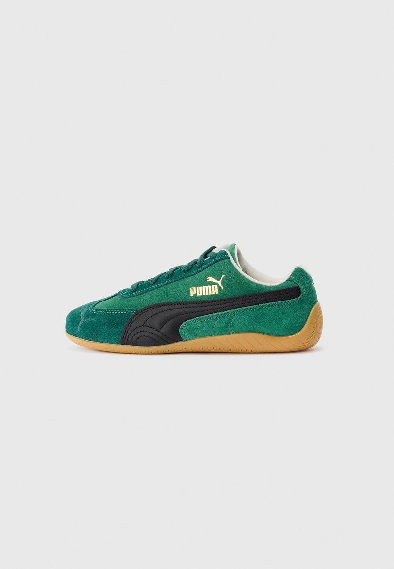 Green suede Puma sneaker with black stripe detailing and gum rubber sole, viewed from the side on a plain white background.