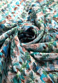 Multikleurige stof met een bloemmotief; bevat blauwe, groene en bruine tinten in een zachte, gladde textuur, gerangschikt in een spiraalvormig ontwerp.