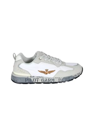 Sneaker bassa bianca e grigia con lacci frontali, emblema alato marrone sul lato e suola nera con design testuale stencil.