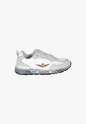 Sneaker bassa bianca e grigia con lacci frontali, emblema alato marrone sul lato e suola nera con design testuale stencil.