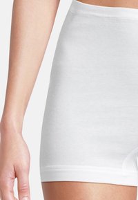 Weiße Baumwollshorts mit gerippter Textur und einem mittelhohen Bund. Der Saum ist glatt und sorgt für eine enganliegende Passform mit minimalen Nähten.