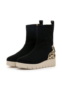 Botas de tobillo de ante negro con un acento de estampado de leopardo y suela de goma beige. Cuentan con un zipper lateral y lengüetas en la parte posterior para facilitar su uso.