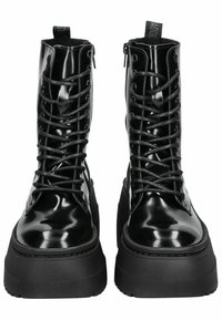 Botas de combate de charol negro con punta redonda, suela de plataforma gruesa y cordones en la parte delantera, con ojales metálicos y una lengüeta.