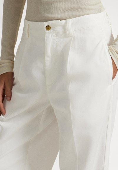 Hvite skreddersydde bukser med en skarp finish, med sidelommer, enkelt knappestenging og et strukturert leggdesign.