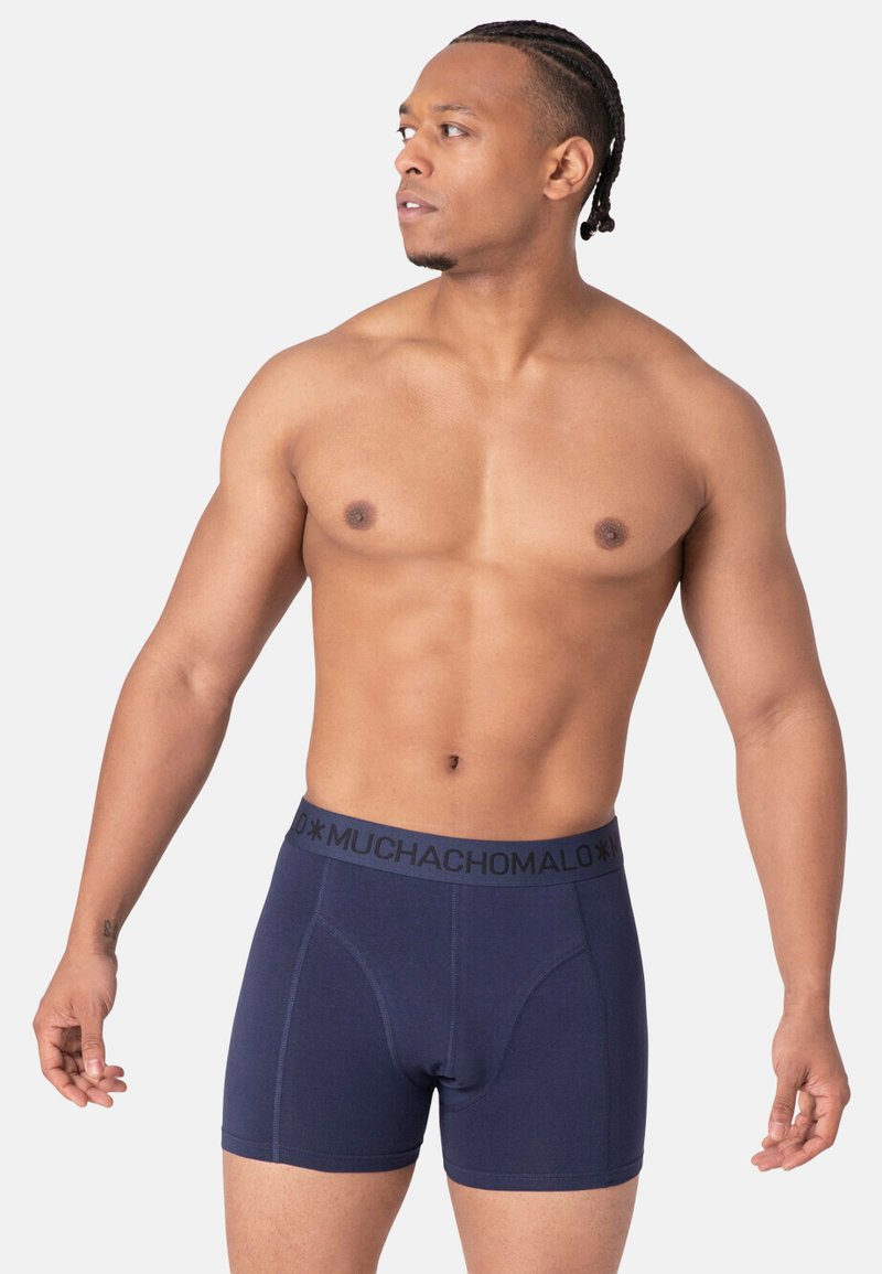 Navy blue boxer briefs made of soft fabric, featuring a black logo waistband and a fitted design with structured front panel.