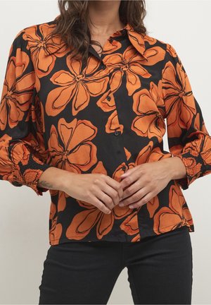 Camicia nera con grande motivo floreale arancione, design con bottoni, polsini elasticizzati e una vestibilità rilassata. Texture del tessuto liscia.