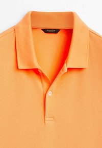 Polo orange pour homme à manches courtes avec col et patte à deux boutons, fabriqué en tissu texturé.