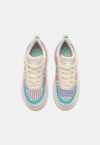 Baskets de couleur crème avec un design en maille texturée comportant des motifs tissés multicolores. Comprend une languette rembourrée et des accents bleus contrastants.