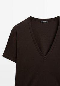 T-shirt à manches courtes de couleur brun foncé avec un col en V profond et des coutures visibles sur les manches et le col, étiqueté Massimo Dutti.