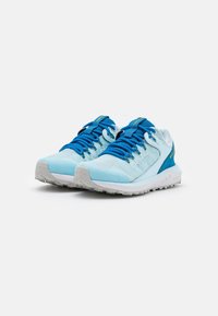 Zapatillas deportivas de color azul claro con parte superior de malla, cordones azules en contraste, cuello acolchado y suela de goma blanca texturizada.