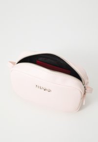 Pochette in pelle testurizzata rosa con zip argentata e logo. All'interno presenta una fodera scura con un portacarte rosso visibile. Forma compatta e rettangolare.