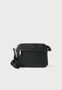 Černá kožená crossbody taška s texturovaným povrchem, vybavená přední kapsou na zip a nastavitelným popruhem. Součástí jsou kovový zip a kovové doplňky.