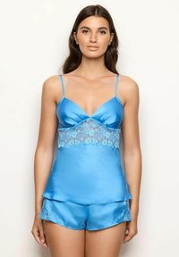 Blauwe satijnen camisole en short set met bloemige kantdetails op de taille, delicate bandjes en een gelaagd ontwerp voor extra textuur.