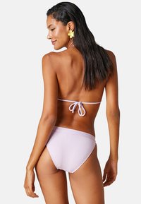 Lila bikini med strukturerad tyg, med knyt bak och lågt skurna bottoms, som erbjuder en enkel och slät design.