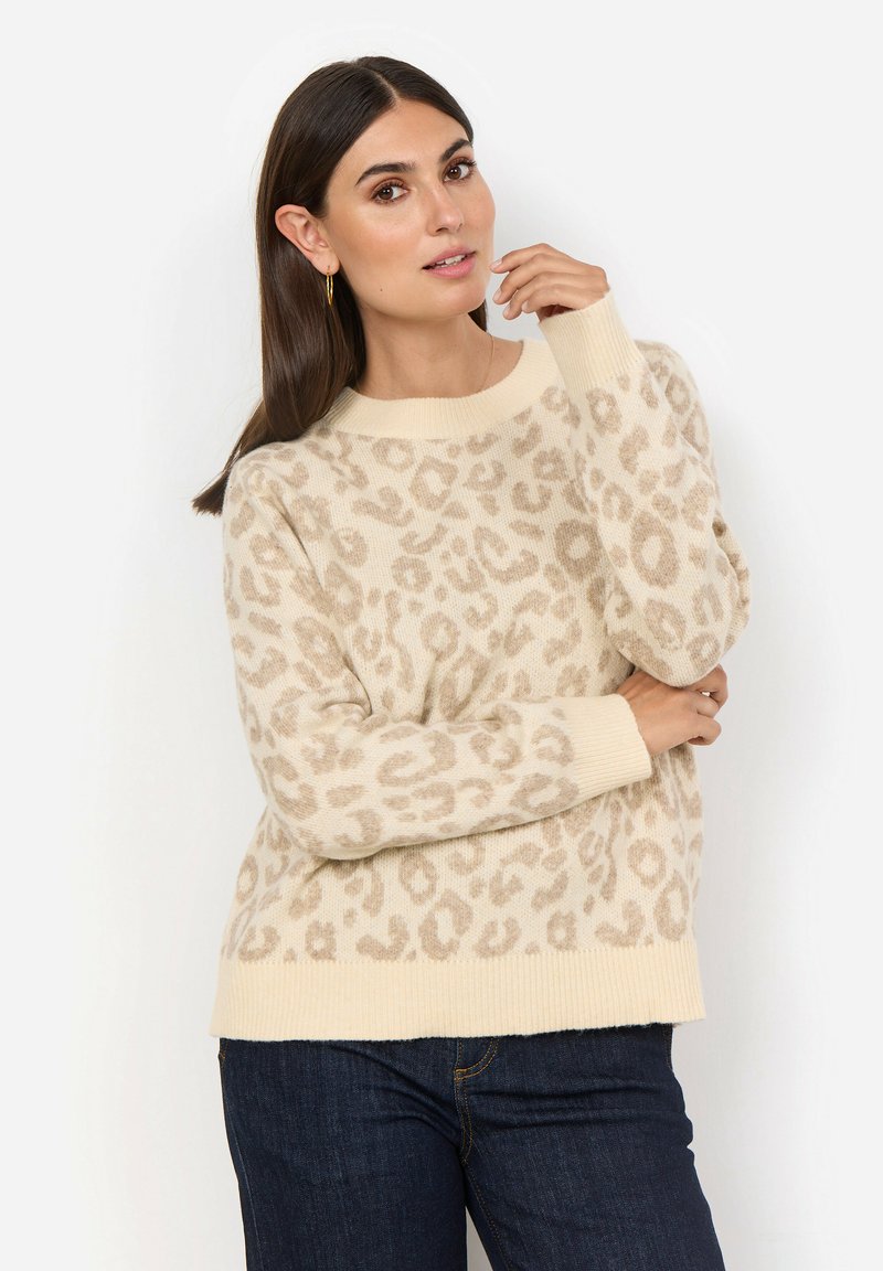 Beige tröja med leopardmönster, ribbade ärmslut och nederkant, mjuk textur, rund halsringning. Kombinerad med mörka jeans.
