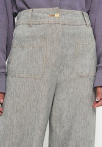 Cotton blend trousers in gray with a subtle striped pattern, featuring a button closure, front pockets, and contrasting stitching.