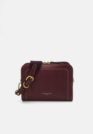 Burgundy leather bag with a textured finish, gold hardware, and contrasting white stitching. Features a detachable strap and zip closure.