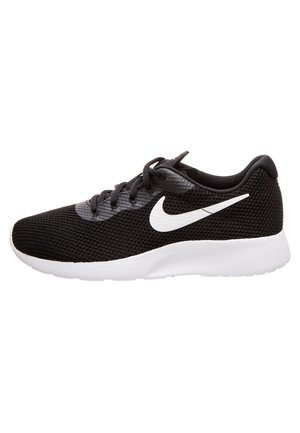 Czarny but do biegania Nike z białym logo swoosh, czarnymi sznurówkami, oddychającą siateczką na cholewce i grubą białą podeszwą.