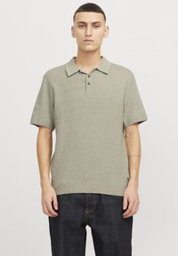 Camisa polo de manga corta en verde claro, de tejido de punto texturizado con cuello con solapas, tapeta de dos botones y dobladillo acanalado. Corte casual.