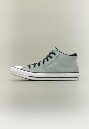 Jasnozielony sneaker typu high-top z czarnymi sznurówkami, białą gumową podeszwą i czarnym paskiem na neutralnym tle.