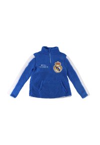 Pullover in pile blu con zip a metà, accenti bianchi sulle maniche, testo "REAL MADRID" e stemma ricamato sul petto. Tessuto morbido e testurizzato.