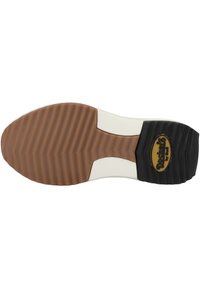 Brown rubber outsole with zigzag tread pattern, cream midsole, black heel with logo accent. Smooth texture, durable design.