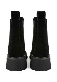 Black suede ankle boots with a chunky black rubber sole, elastic side panels, and pull tabs at the back for easy wear.