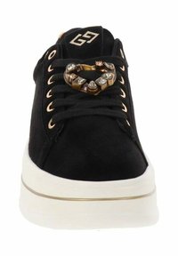 Czarne zamszowe sneakersy z białą podeszwą, zdobione metalowym akcentem w kształcie serca, złotymi oczkami i czarnymi sznurówkami.