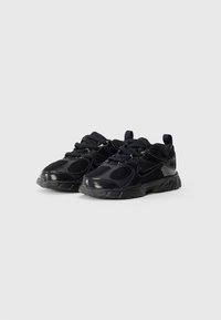 Sapatos desportivos pretos com um upper em malha, sola de borracha, colarinho acolchoado e fecho de atacador com um acabamento texturizado e design elegante.