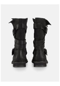 Botas de cuero negras con paneles texturizados, correas, hebillas y tacón elevado. La vista trasera muestra un diseño resistente y costuras definidas.